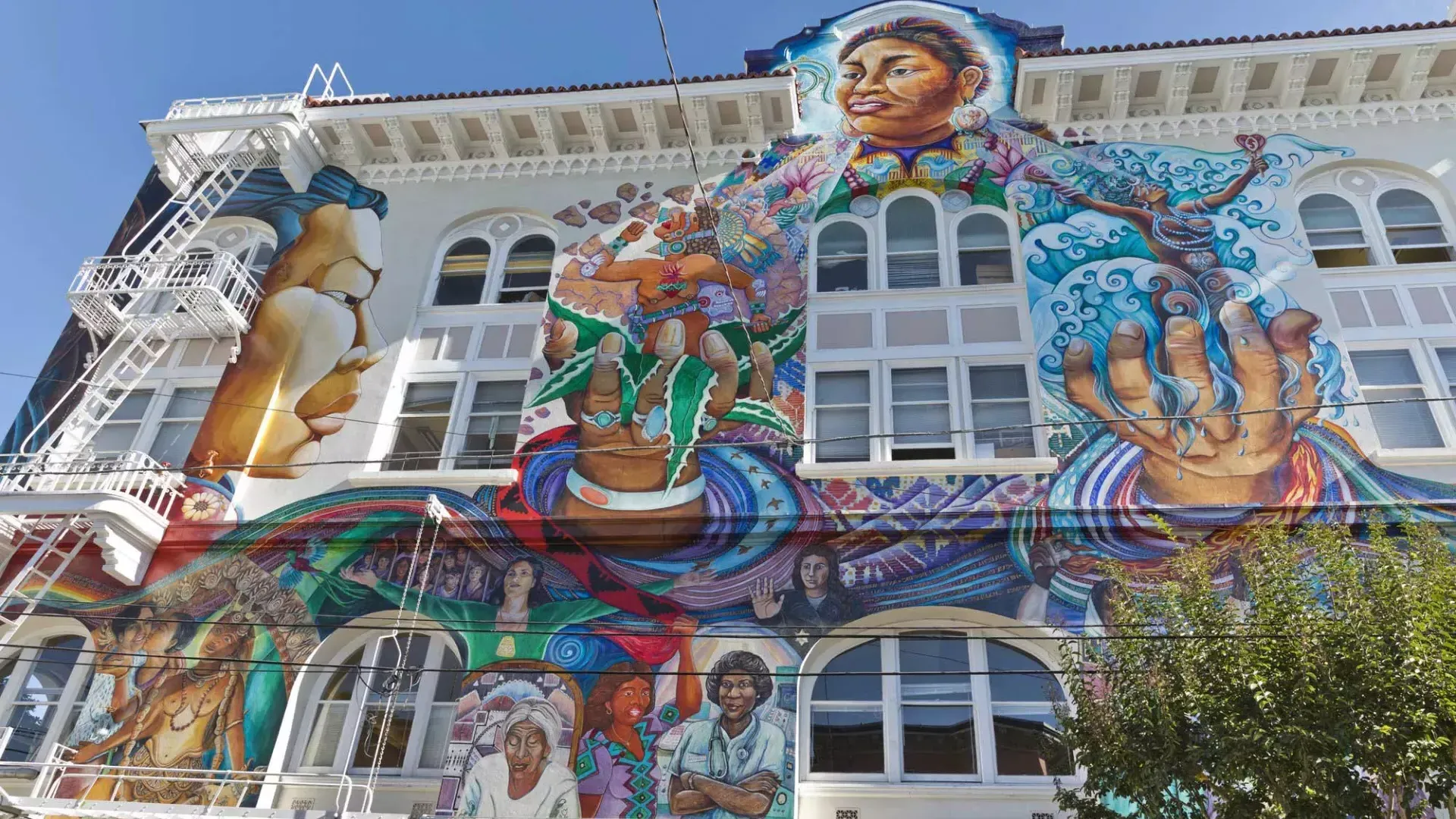 Um mural colorido e grande cobre a lateral do Edifício das Mulheres no Distrito Mission, em São Francisco.